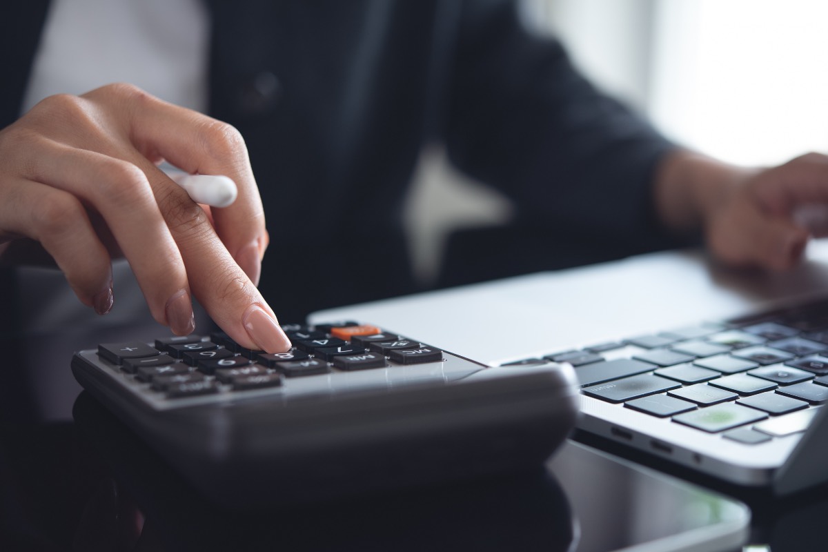 Femme avec calculatrice qui calcule le budget ASC