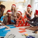 Collègues construisant des tours de papier pour le team building de Noël